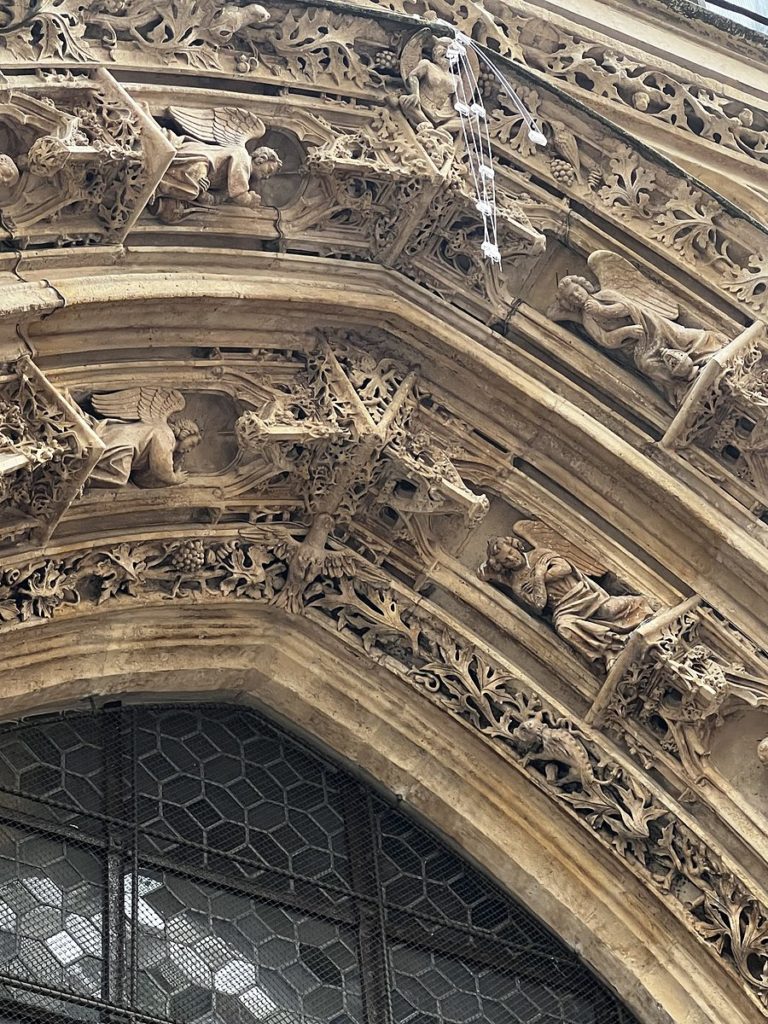 Intricate Gothic stone carvings of angels and foliage over a Paris church doorway