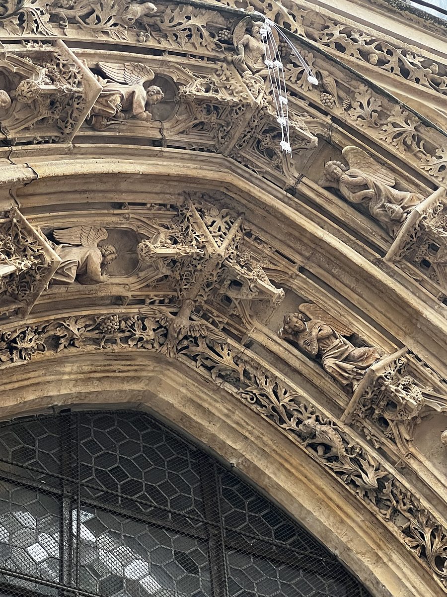 Intricate Gothic stone carvings of angels and foliage over a Paris church doorway