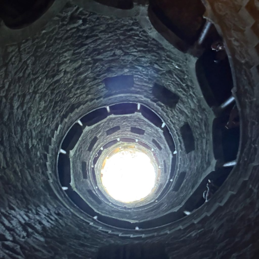 Looking up the spiral Initiation Well at Quinta da Regaleira in Sintra towards the light above