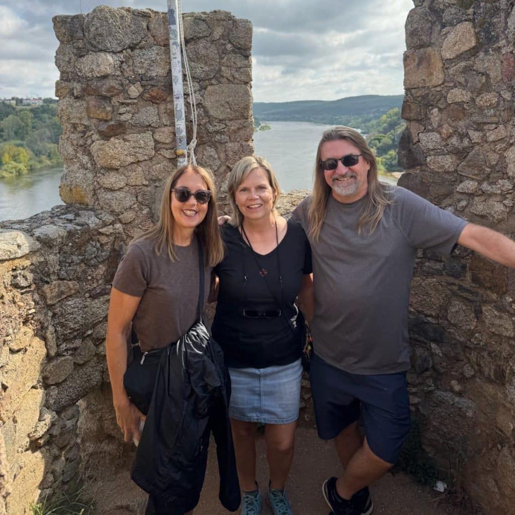 Three readers smiling on the battlements of Almourol Castle above the River Tagus