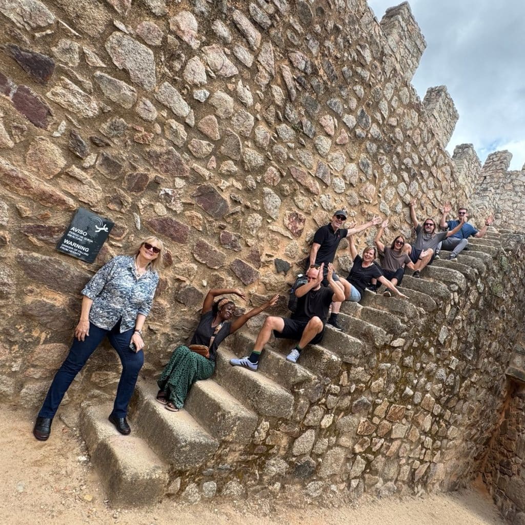 Readers sitting and waving on a steep stone staircase inside the walls of Almourol Castle