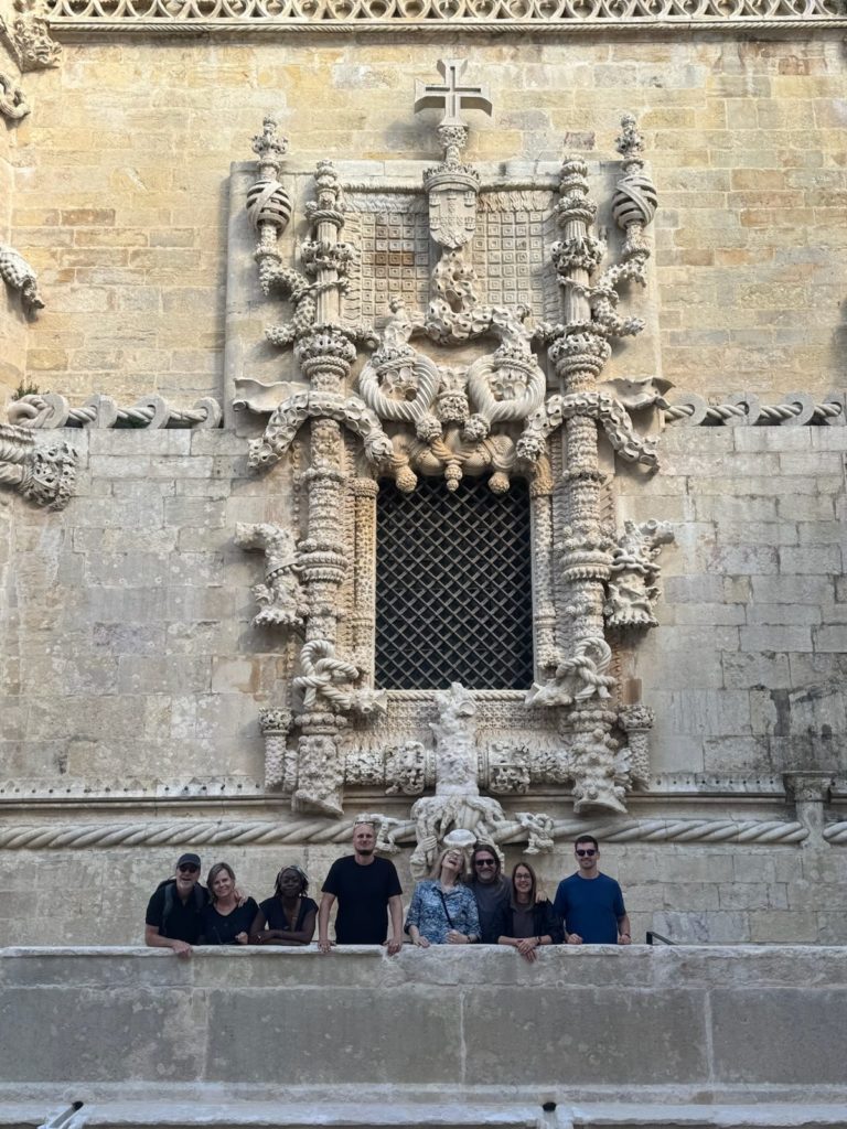 Readers beneath the ornate Manueline window of the Convent of Christ in Tomar, Portugal
