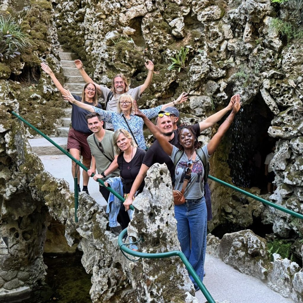 Readers with arms raised on a footbridge among the grottoes of Quinta da Regaleira, Sintra