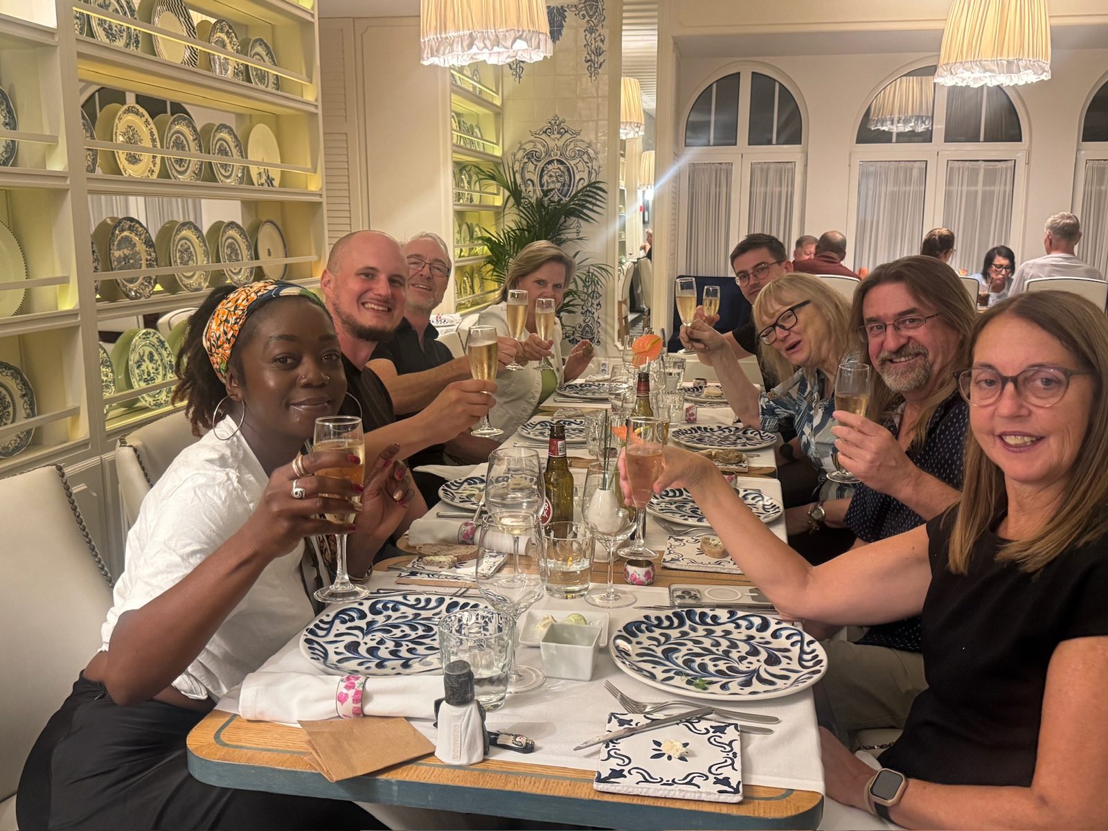 Readers raising glasses of sparkling wine at a celebration dinner in Lisbon